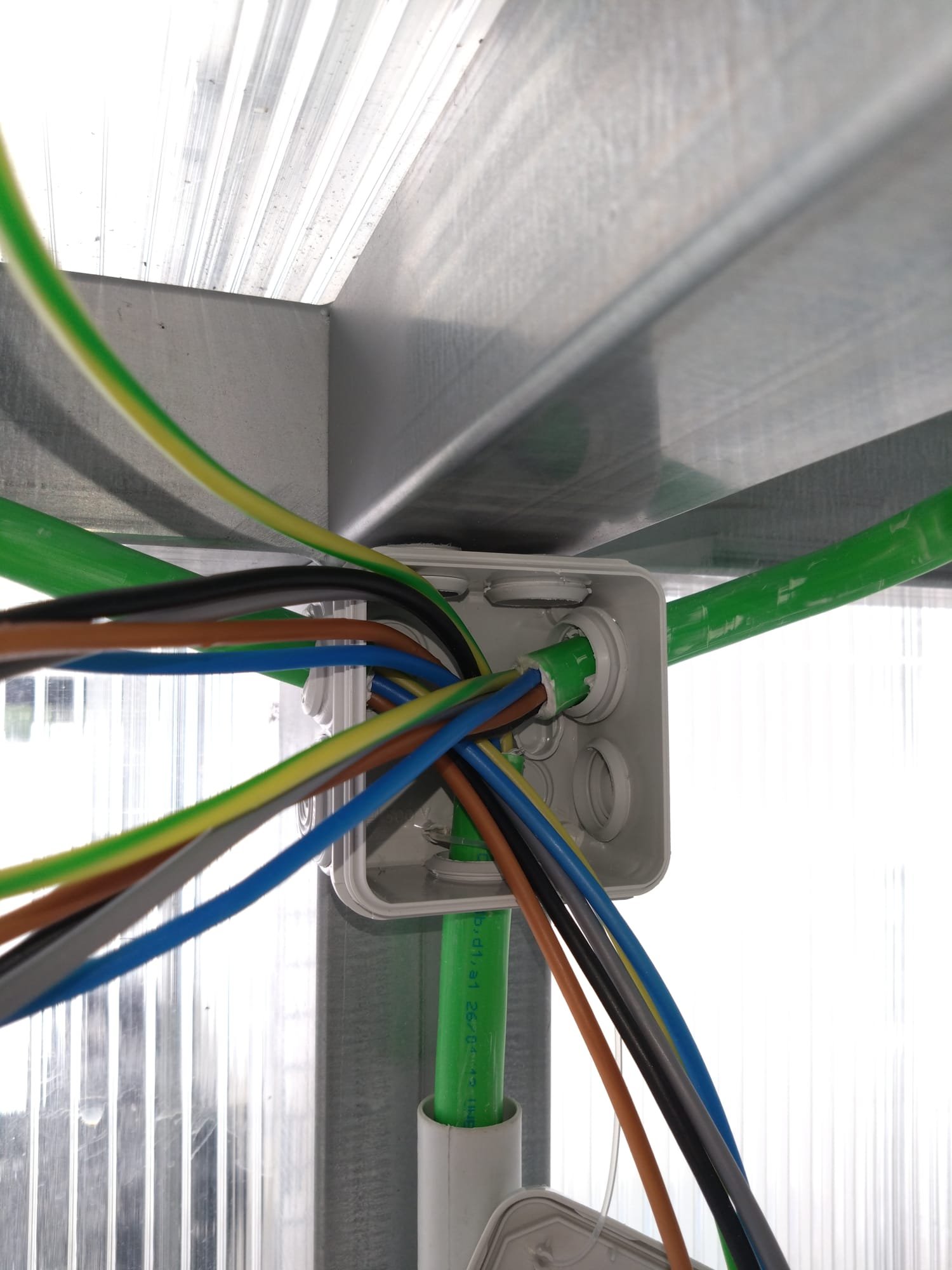 Junction box on a steel frame, with cables arriving through green conduit